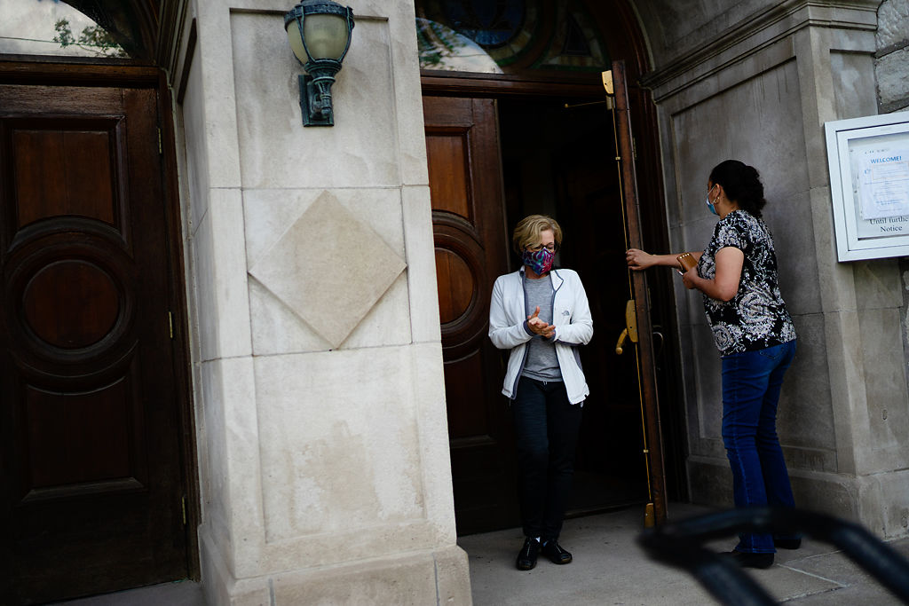 Maribel Arzate holds the door open for Kathy Concannon
